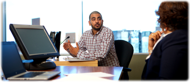 A witness gestures while speaking to an adjudicator during a hearing.